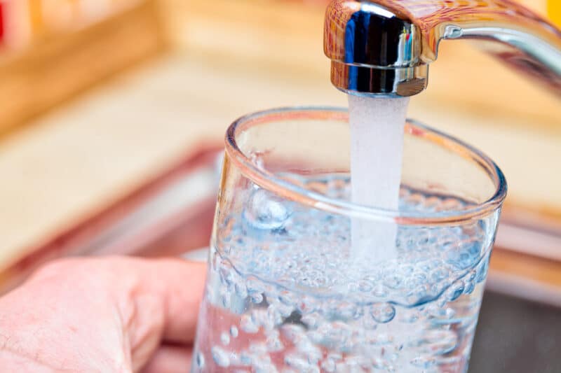 Filling up a glass with drinking water from kitchen tap