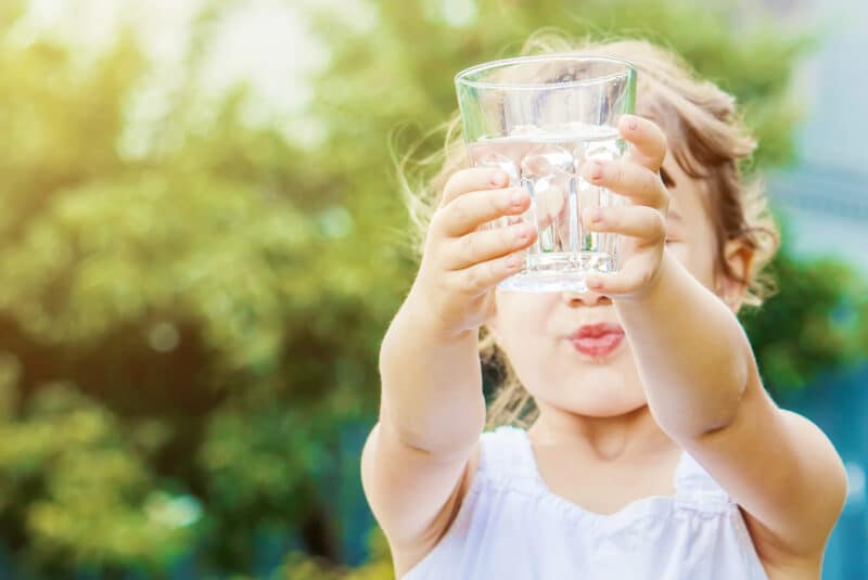child hold a glass of clean drinking water