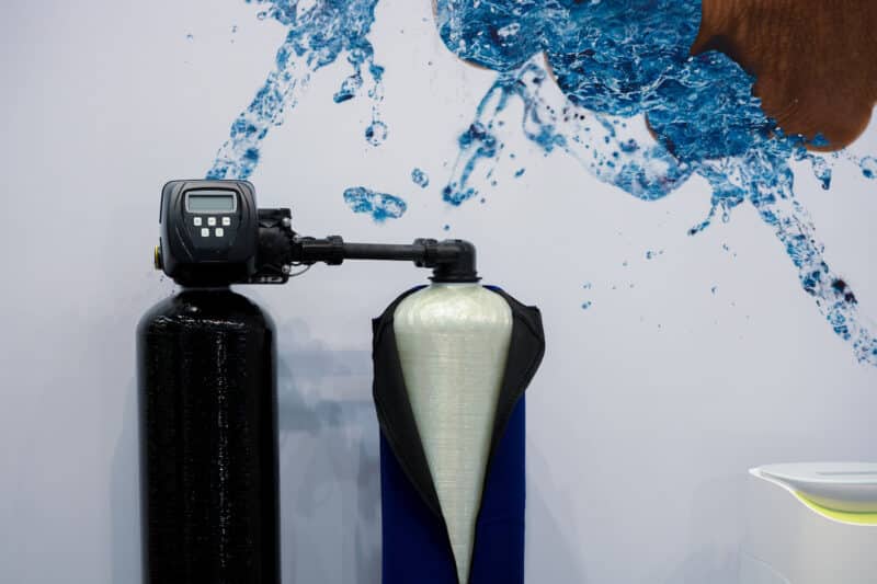 two tall black water softener systems against a white wall